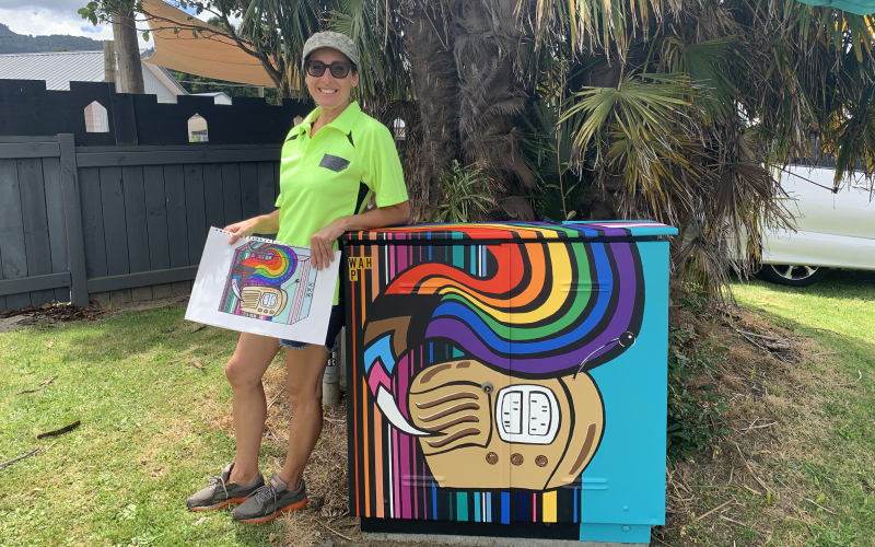 Artist Lyn Randall with her colourful diversity themed Chorus Cabinet, with a nod to Akrad Radio